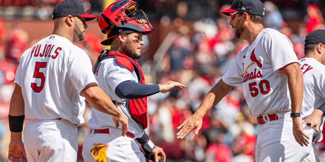 Albert Pujols (5), Yadier Molina, center, and Adam Wainwright of the St. Louis Cardinals celebrate after a game at Busch Stadium in St. Louis, Missouri, on Aug. 4, 2022.