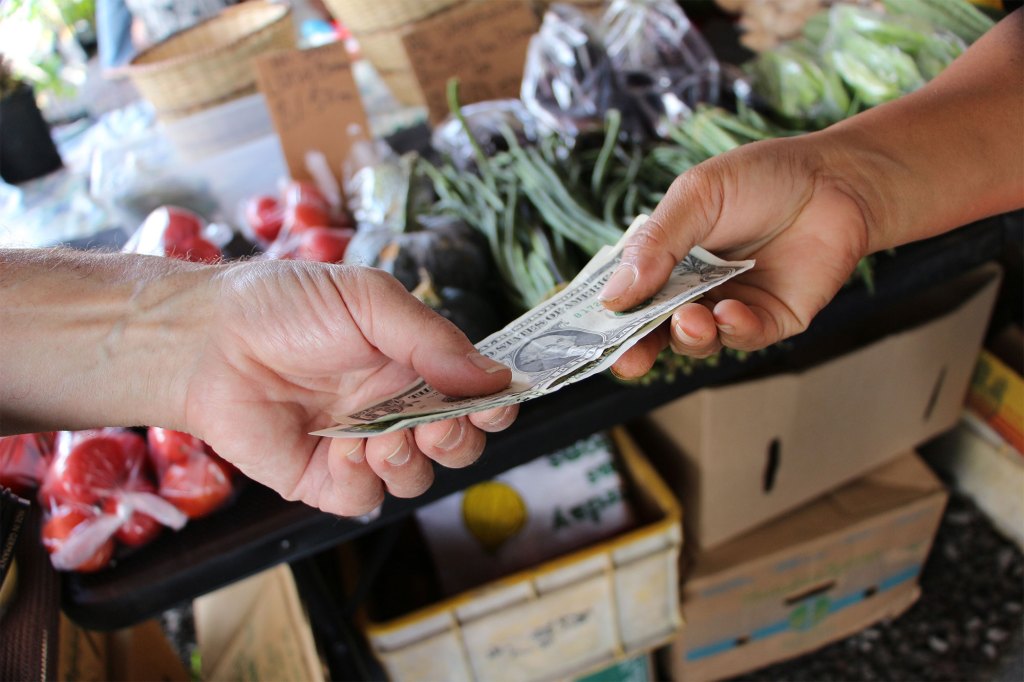 two hands exchanging cash