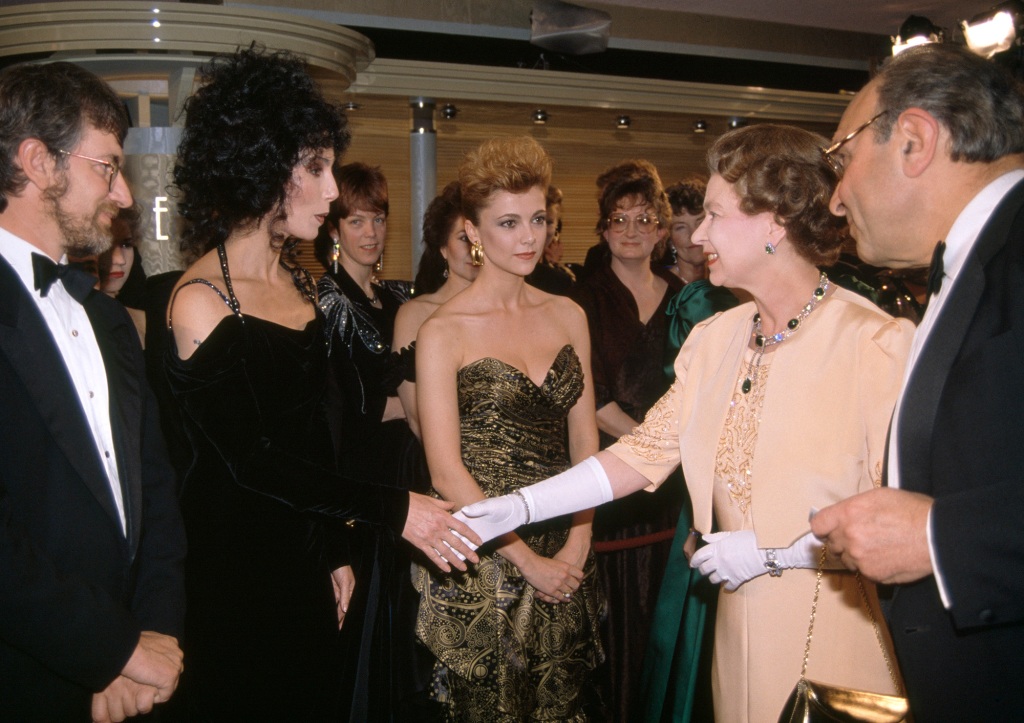 Cher is seen shaking hands with Her Majesty at the premiere of Steven Spielberg’s "Empire of the Sun" in 1988.