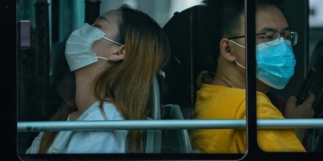 Commuters wearing face masks ride on a bus during the morning rush hour in Beijing, Wednesday, Sept. 14, 2022. (AP Photo/Andy Wong)