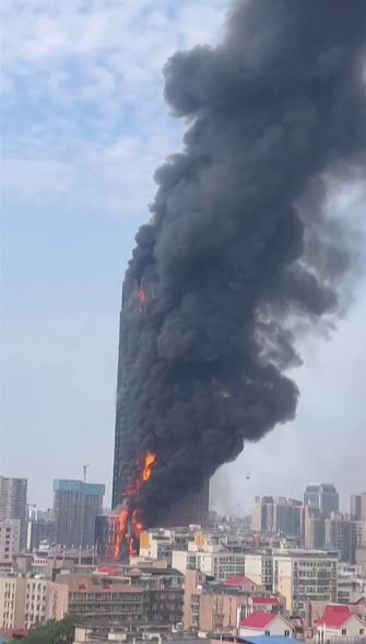 Thick black smoke filled the sky around the burning skyscraper.