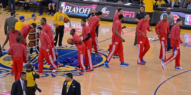 Los Angeles Clippers players remove their warm-up jackets in protest over alleged racist remarks by owner Donald Sterling before playing the Golden State Warriors in Game 4 of their Western Conference playoff series at Oracle Arena in Oakland, California, on April 27, 2014.