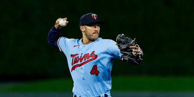 Carlos Correa of the Minnesota Twins throws to first base to get out Josh Harrison of the Chicago White Sox in a game at Target Field Sept. 27, 2022, in Minneapolis.  