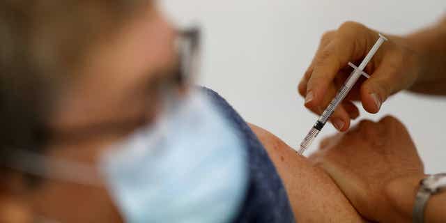 The UK plans on offering free COVID booster shots to all adults starting in Sept. 2022. Pictured: nurse administers a COVID-19 vaccine to a patient at a vaccination center in Ancenis-Saint-Gereon, France, on Nov. 17, 2021.