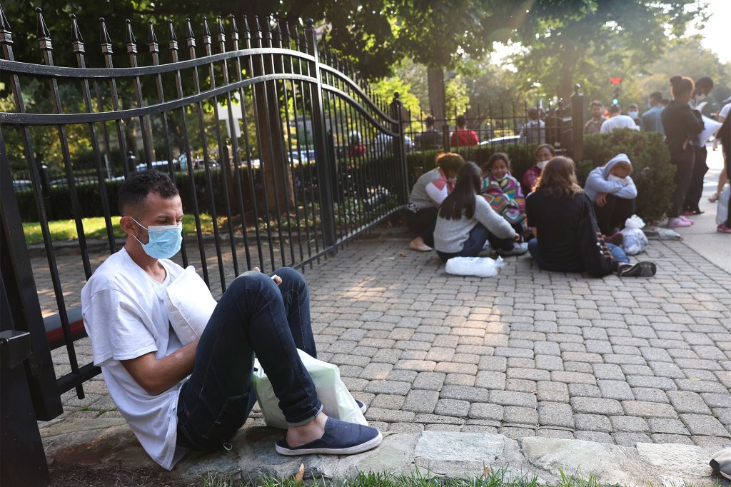 Migrants from Central and South America wait near the residence of US Vice President Kamala Harris after being dropped off on September 15