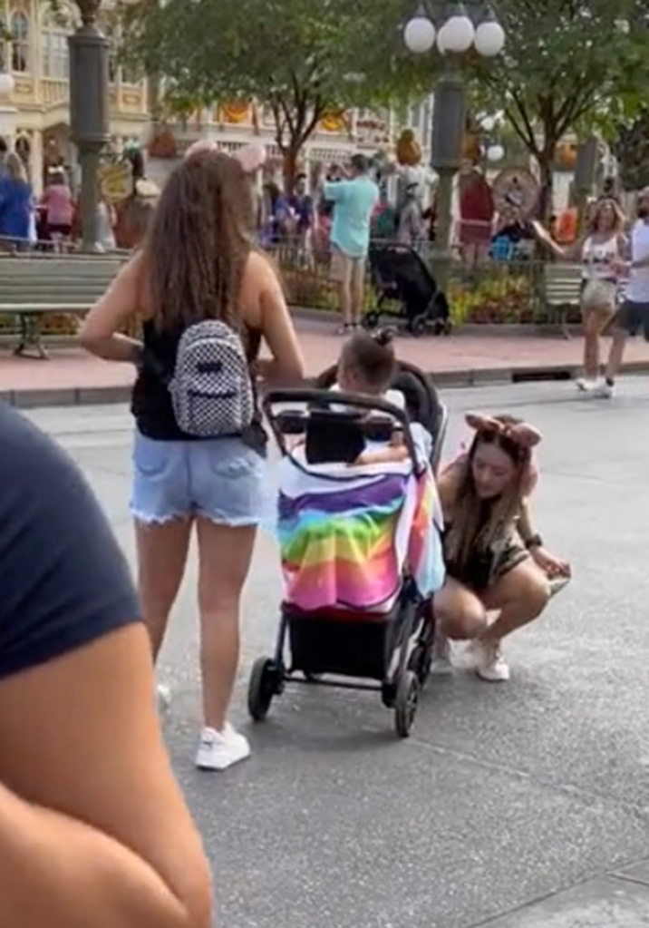 Once past the Disney worker, the woman picked the girl out of the stroller. 