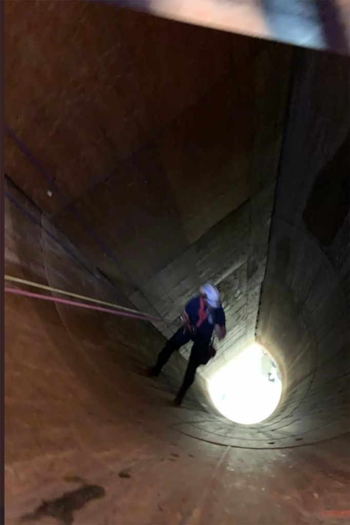 A fire rescuer searches for the man who repelled 85 feet down the Minneapolis storm drain.