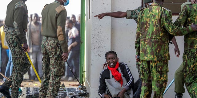 A woman lies on the floor after being crushed in a stampede when security forces kept others back, after they forced their way into Kasarani stadium where the inauguration of Kenya's new president William Ruto is due to take place later today, in Nairobi, Kenya Tuesday, Sept. 13, 2022. 