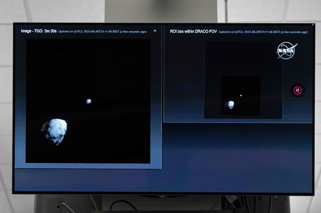 A television at NASA's Kennedy Space Center in Cape Canaveral, Florida captures the final images from the Double Asteroid Redirection Test (DART) as it approaches asteroid Dimorphos (R), past asteroid Didymos (L).