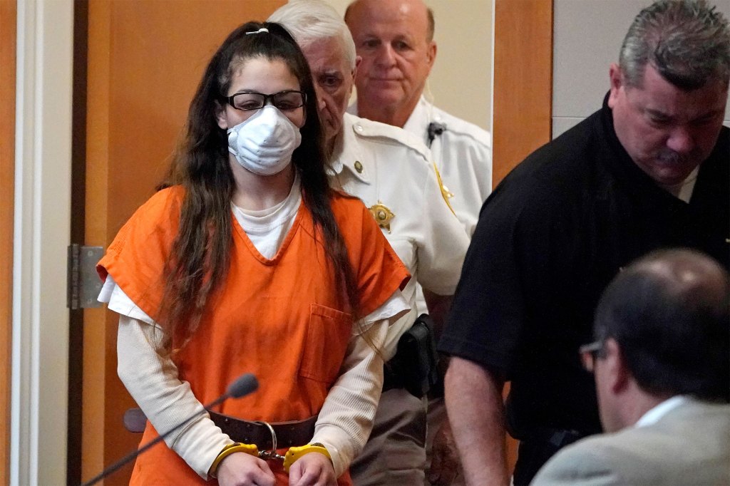 Kayla Montgomery in an orange jumpsuit and cuffs in court