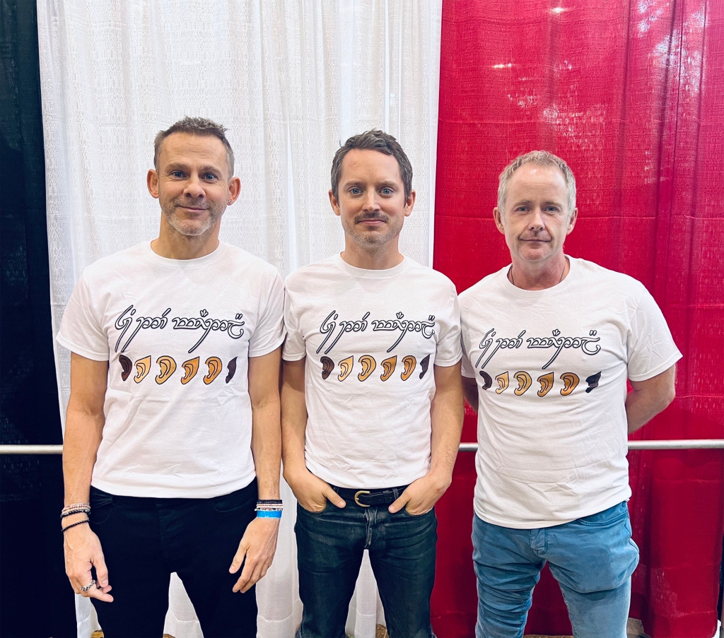 Elijah Wood (center)  Billy Boyd (right) and Dominic Monaghan (left) shared a photo of themselves wearing a shirt saying "You are welcome here."