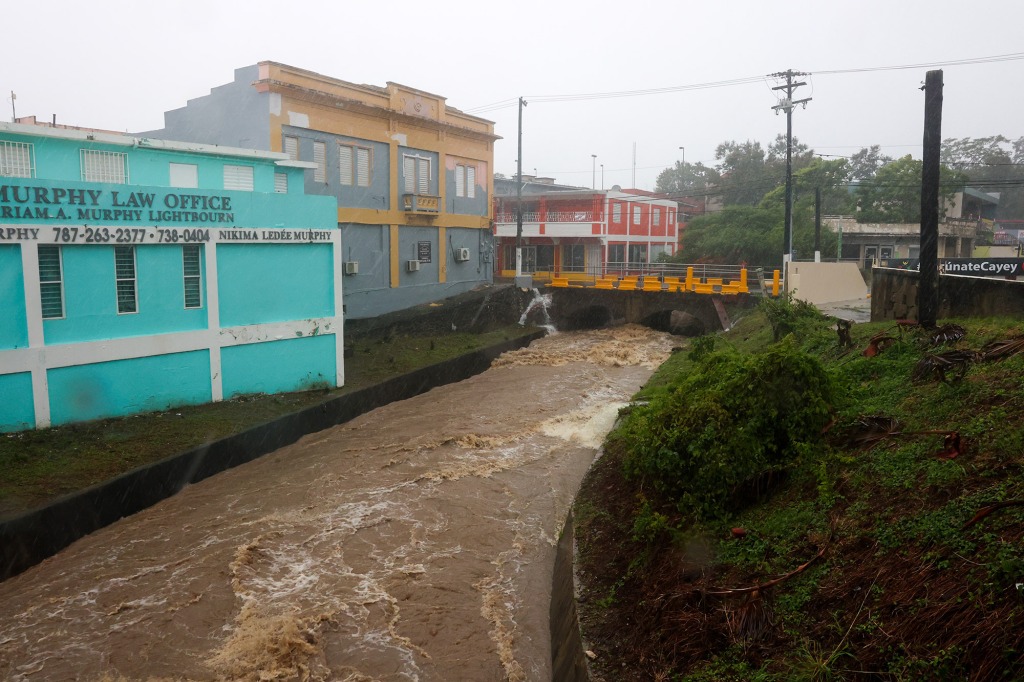 A river swollen with rain caused by Hurricane Fiona speeds through Cayey, Puerto Rico, Sunday,