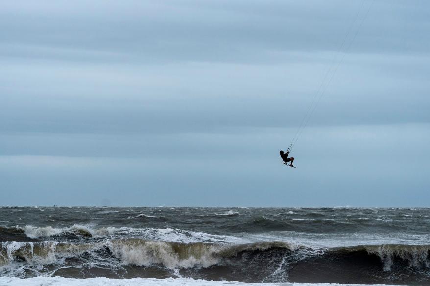 Billy Myers, from Savannah, Ga., kitesurfs in the rough surf caused by Hurricane Ian, Thursday, Sept. 29, 2022, in Tybee Island, Ga. (AP Photo/Alex Brandon)