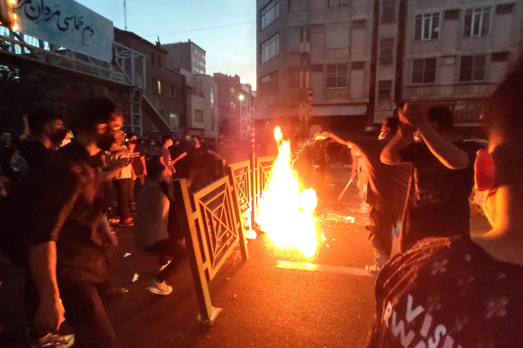 People light a fire during a protest over Mahsa Amini's death, in Tehran, Iran