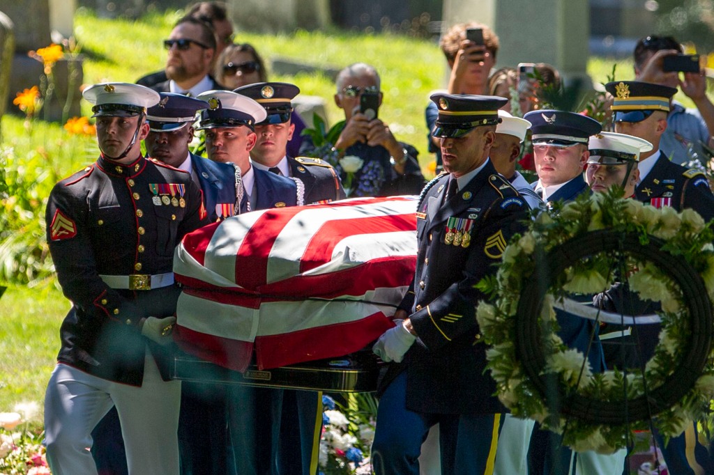 Pallbearers from the US Military are shown carrying Rep. Jackie Walorski's casket, which is covered in an American flag 