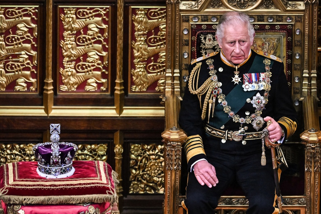 Britain's Prince Charles, Prince of Wales (R) sits by the The Imperial State Crown (L) in the House of Lords Chamber, during the State Opening of Parliament, in the Houses of Parliament, in London, on May 10, 2022.