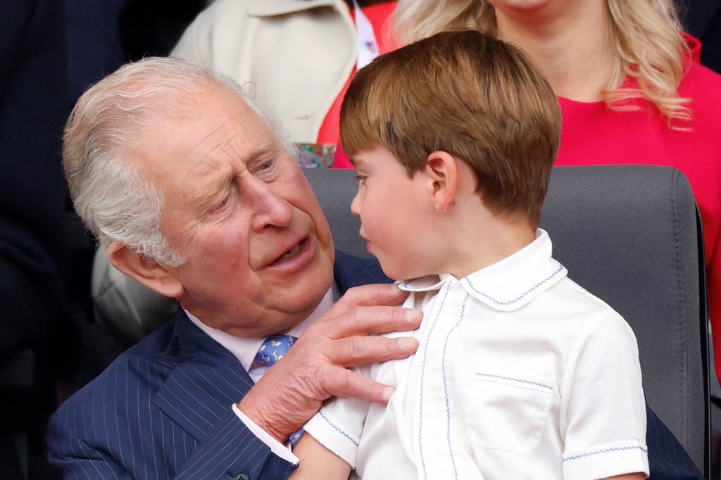Prince Louis of Cambridge sits on his grandfather Prince Charles, Prince of Wales's lap as they attend the Platinum Pageant on The Mall on June 5, 2022 in London, England. 
