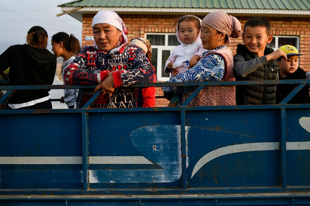 Kyrgyzstan's refugees stand in the back of a truck as they arrive from Batken, the Kyrgyz-Tajik border, to Boz-Adir, southwestern Kyrgyzstan, Saturday, Sept. 17, 2022. 