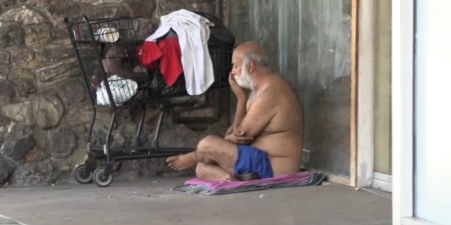 Los Angeles homeless man known for openly defecating on Ventura Blvd. sits by shopping cart. 