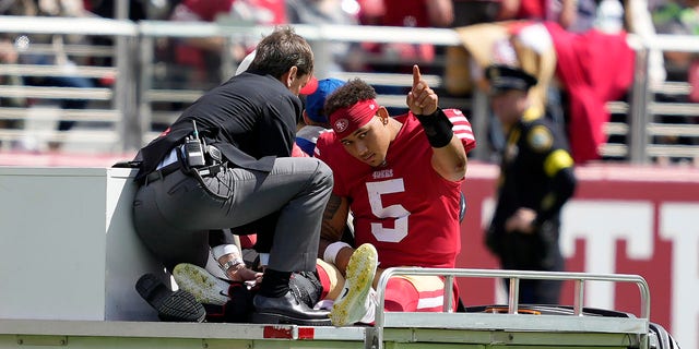 San Francisco 49ers quarterback Trey Lance (5) gestures while being carted off the field during the first half of an NFL football game against the Seattle Seahawks in Santa Clara, Calif., Sunday, Sept. 18, 2022.