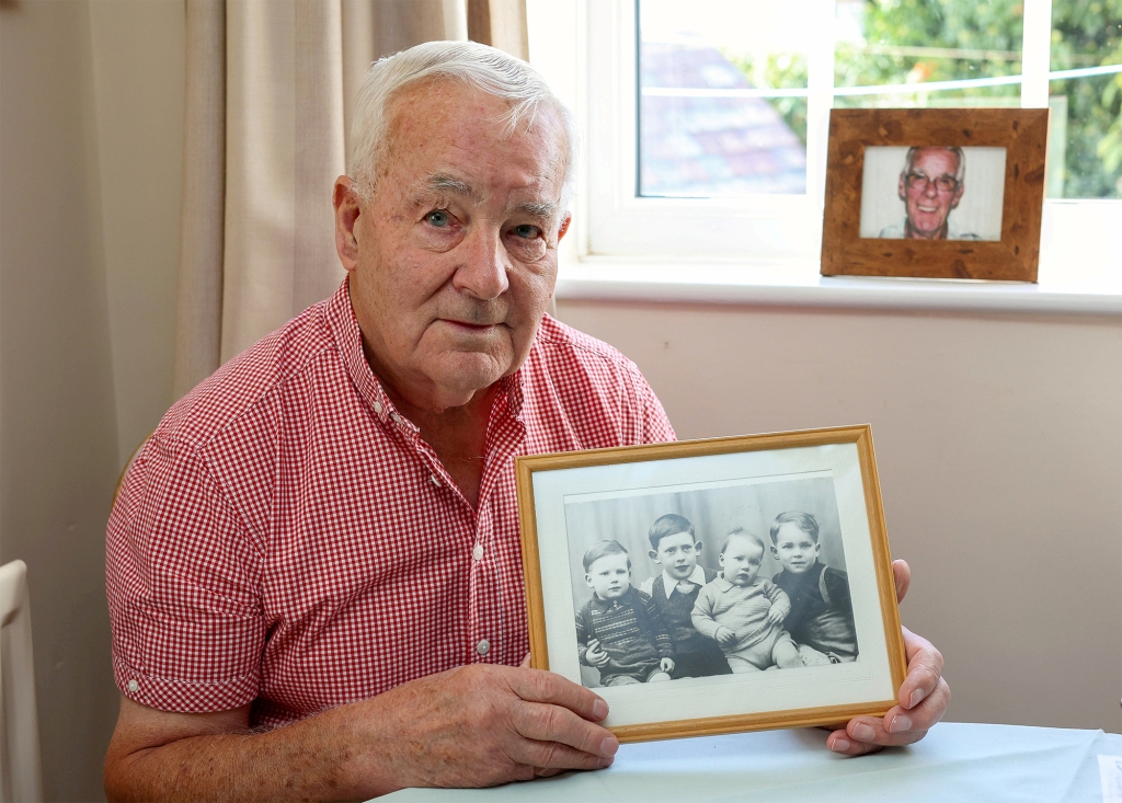 Ted Nobbs at home in Rugby, Warwickshire holding a picture of him with his brothers as children.