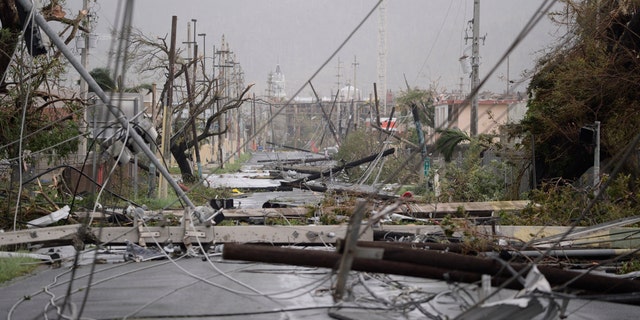 Electricity poles and lines lay toppled on the road in Humacao, Puerto Rico, after Hurricane Maria in 2017.