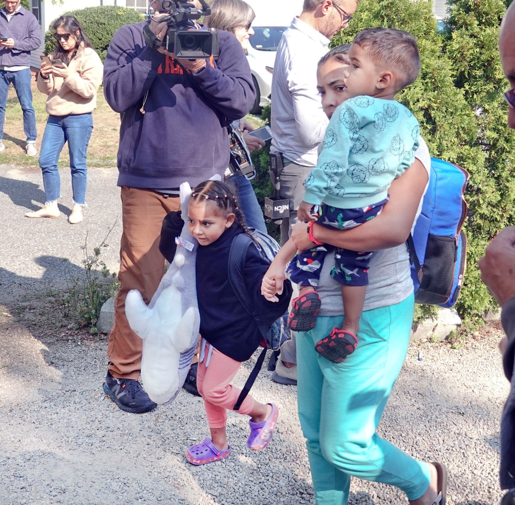 An immigrant family makes their way to the bus transporting from St. Andrews in Edgartown, Mass., to Vineyard Haven and the ferry to Woods Hole, Friday, Sept. 16, 2022.