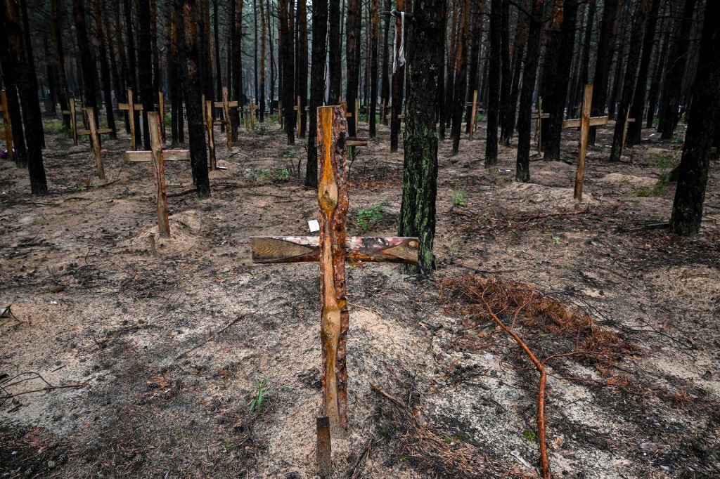 This photograph taken eastern Ukraine on September 16, 2022 shows crosses at a burial site in a forest on the outskirts of Izyum. - Ukraine said on September 16, 2022 it had counted 450 graves at just one burial site near Izyum after recapturing the eastern city from the Russians.