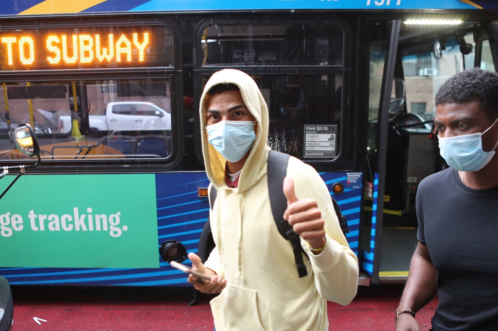 A migrant giving the thumbs up before getting on a MTA bus.