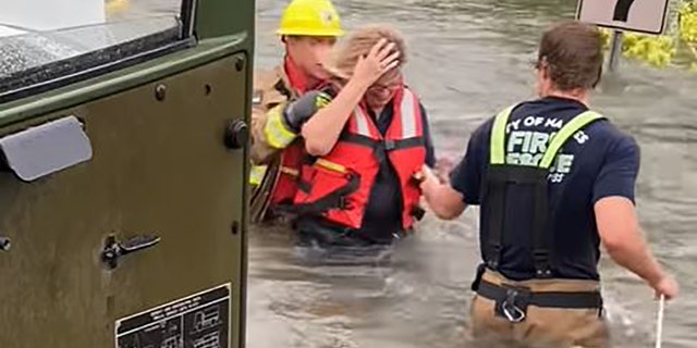 Naples firefighters rescued a woman who was trapped inside her car Wednesday as floodwaters surged around her.