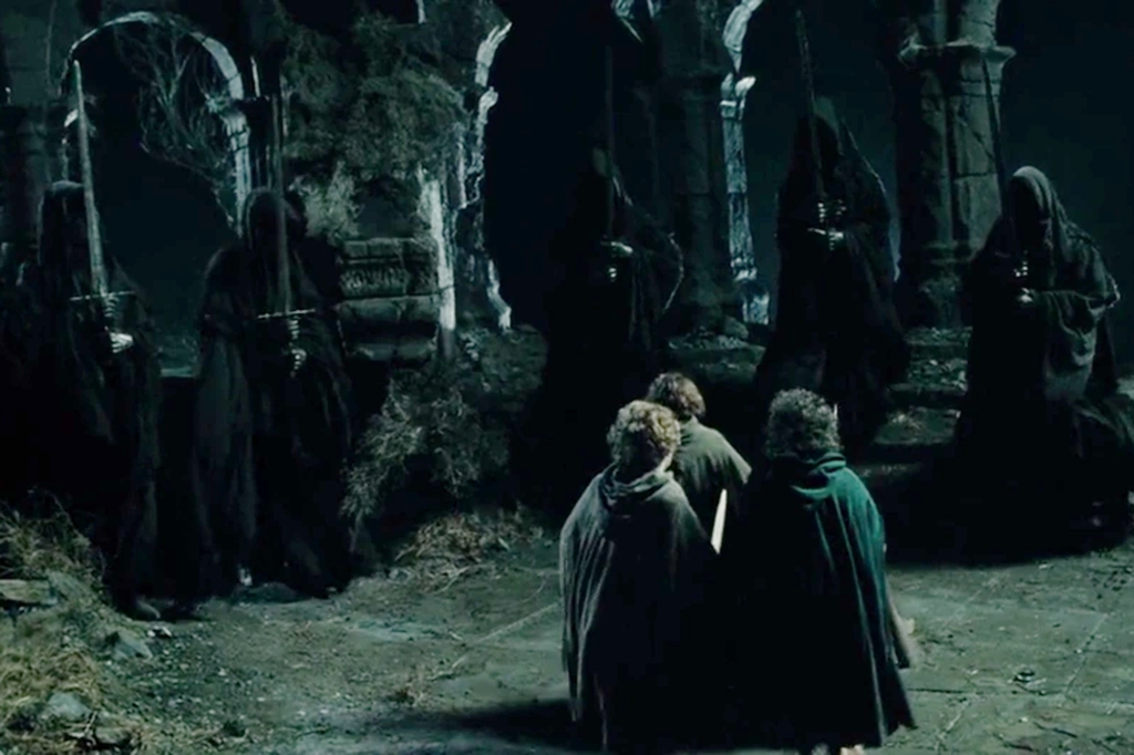 Hobbits face off against hooded black figures. 