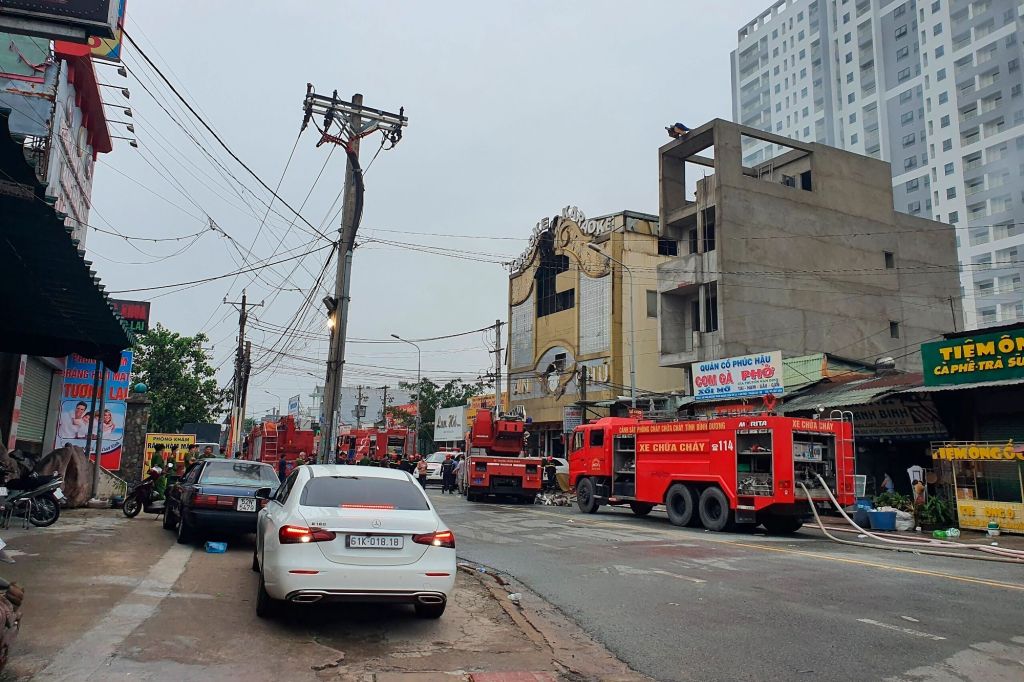 Fire department trucks line outside the karaoke parlor after it caught on fire in Thuan An city on Sept. 7, 2022.