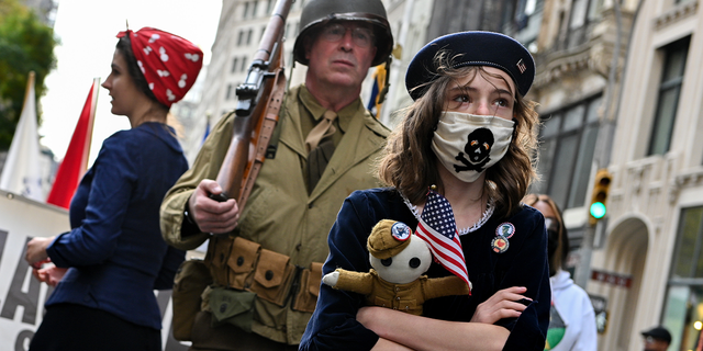 A girl from the Long Island Historical Association dresses as a child during an American Revolution reenactment at the 102nd annual Veterans Day parade on November 11, 2021, in New York City.