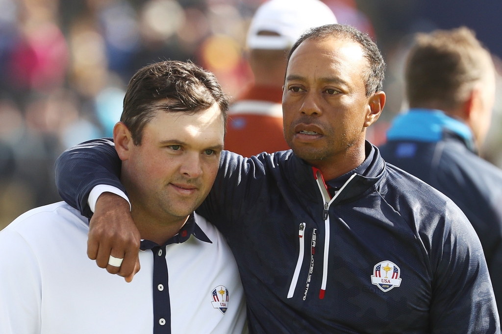 Tiger Woods consoles Reed following defeat during the morning fourball matches of the 2018 Ryder Cup in Paris, France.