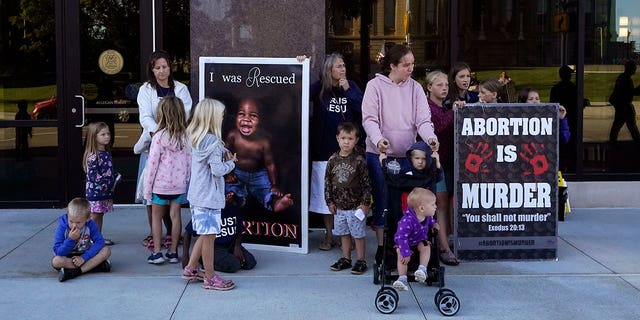 Abortion opponents are seen outside as the Michigan Board of State Canvassers meet during a hearing, Wednesday, Aug. 31, 2022, in Lansing, Mich. 