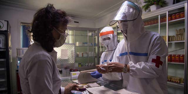 Customs records indicate that North Korea has imported shipments of unspecified COVID vaccines, suggesting the country may begin vaccinating their citizens. Pictured: North Korean health officials in Pyongyang, North Korea, assist a woman at a pharmacy on May 27, 2022.