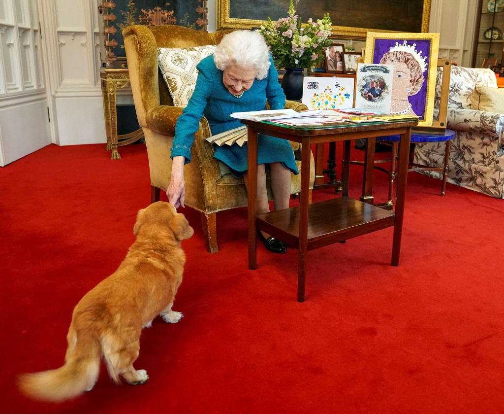 Queen Elizabeth II strokes Candy, her corgi dog, in February 2022.