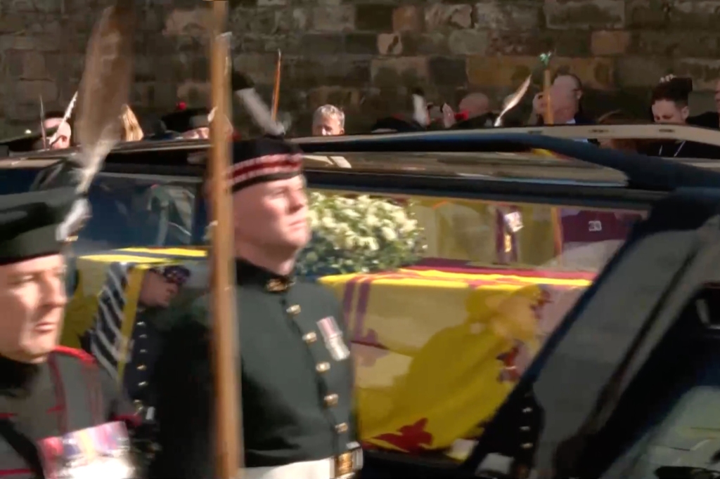 The queen's flag-draped coffin is pictured in the back of a Mercedes hearse along the Royal Mile flanked by thousands of mourners. 