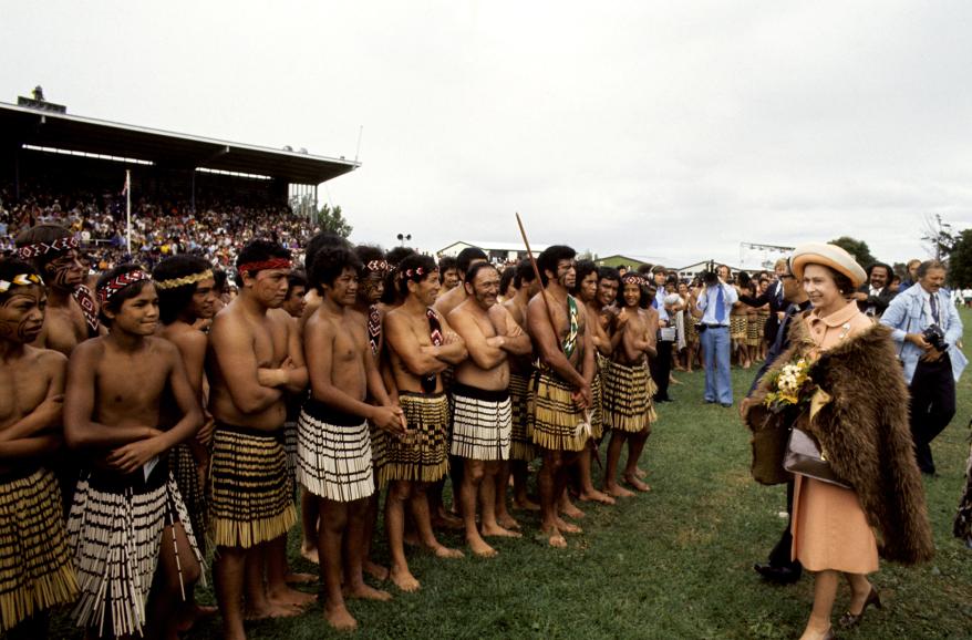 Clad in a cloak made of brown kiwi feathers, Queen Elizabeth, along with the Duke of Edinburgh, enjoyed a typical New Zealand Maori welcome at the opening of the 1977 Royal New Zealand Polynesian Festival.