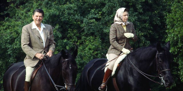 Queen Elizabeth Il rides her horse "Burmese" in Windsor Great Park during a state visit from President Reagan, who is riding "Centennial."