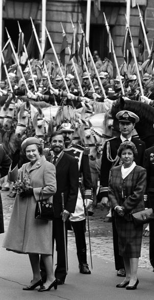 Queen Elizabeth offered her famous wave to the crowd outside Madrid's town hall during a 1988 State visit to Spain. She was accompanied by royal equerry Commander Timothy Laurence.