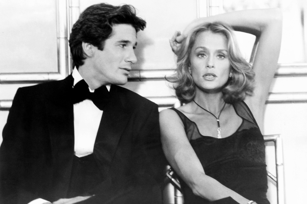 Richard Gere looking sideways at Lauren Hutton, who looks at the camera. 