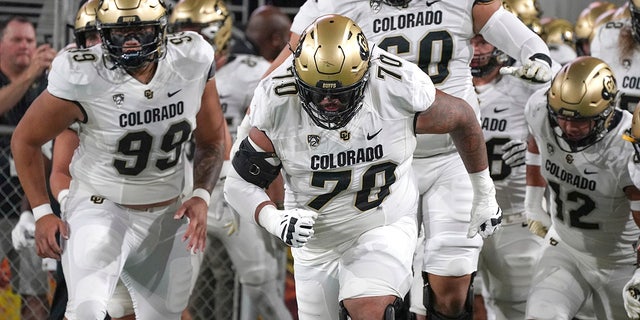 FILE - Colorado players lead by Casey Roddick (70) charge out onto the field before their NCAA college football game with Arizona State, Sept 25, 2021, in Tempe, Ariz. Colorado offensive lineman Casey Roddick nearly had his football career ended after a case of COVID-19 developed into a serious bout with myocarditis, an inflammation of the heart wall. These days, the left guard from California doesn't take even one snap for granted. That's why he relished his new role as team captain.