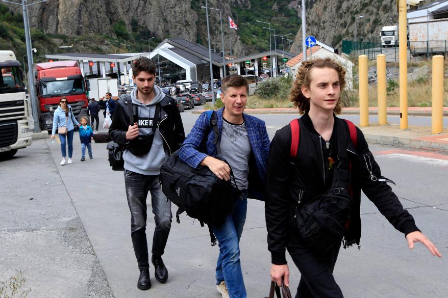 A picture of a group of young Russians walking along the border crossing Lars between Georgia and Russia.