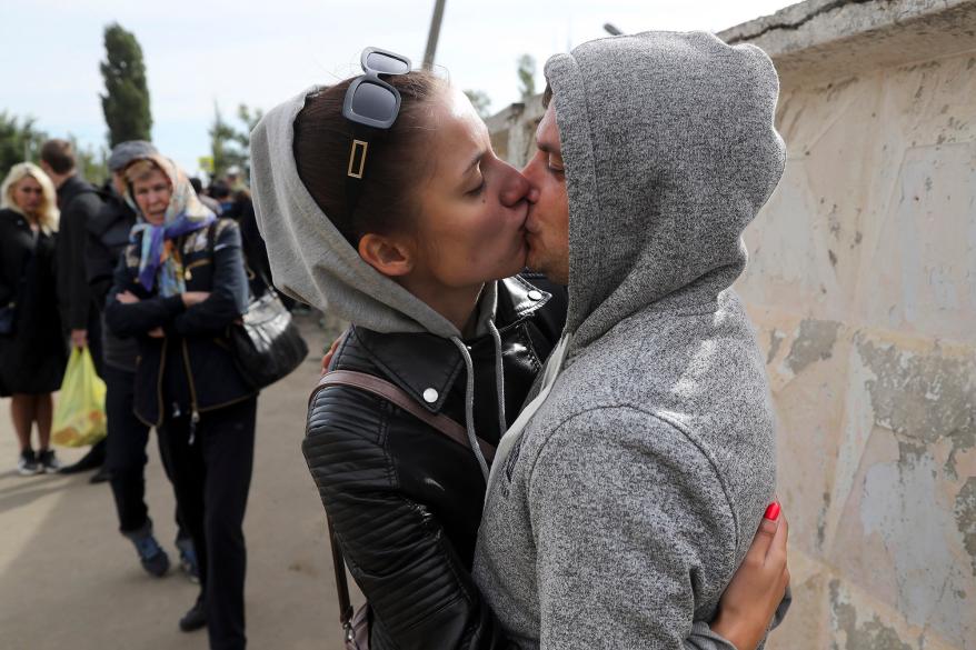 A picture of a Russian recruit kissing his wife goodbye.