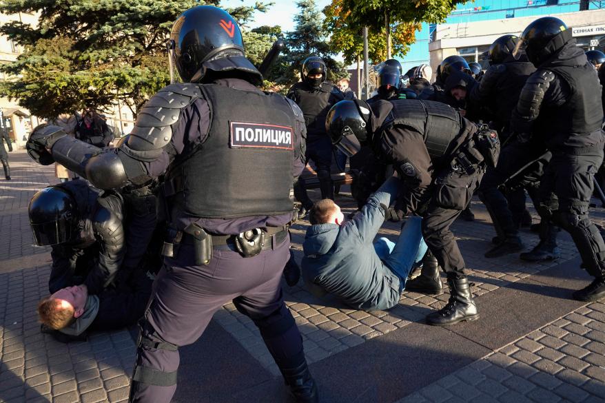 A picture of Russian police detaining a protestor.