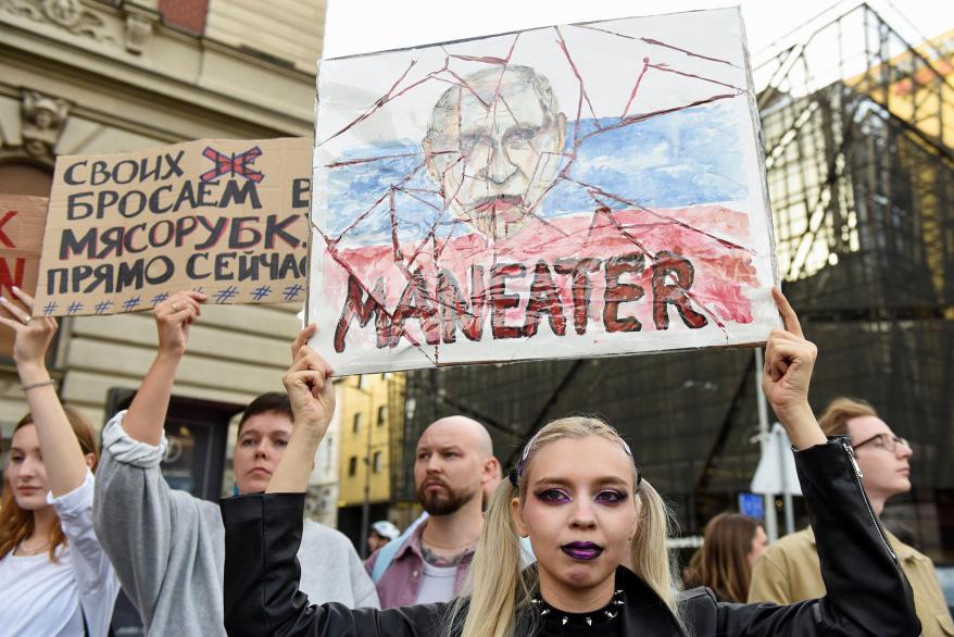 A picture of a woman holding a banner during a protest against the mobilization of Russians for war.