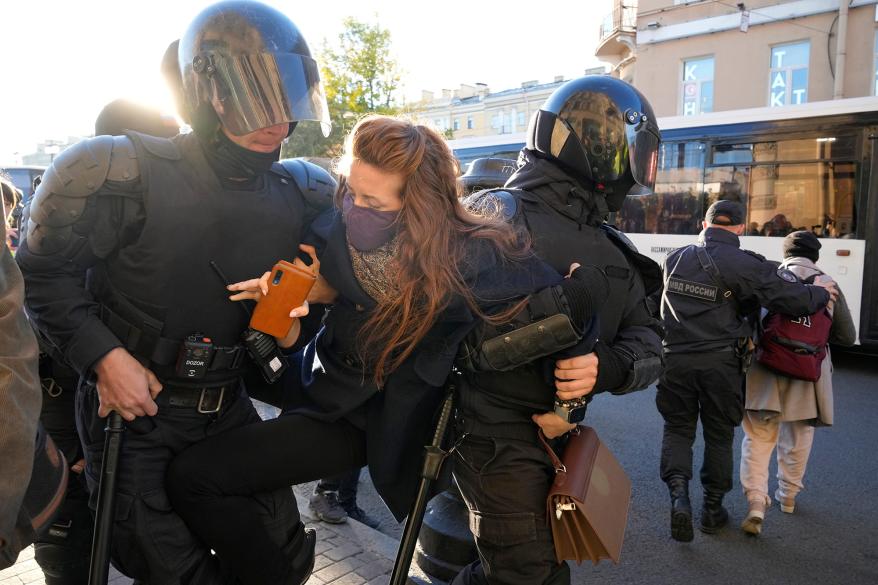 A picture of Russian police detaining a protestor.