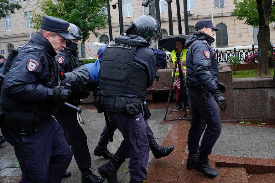 A picture of Russian police detaining a protestor.