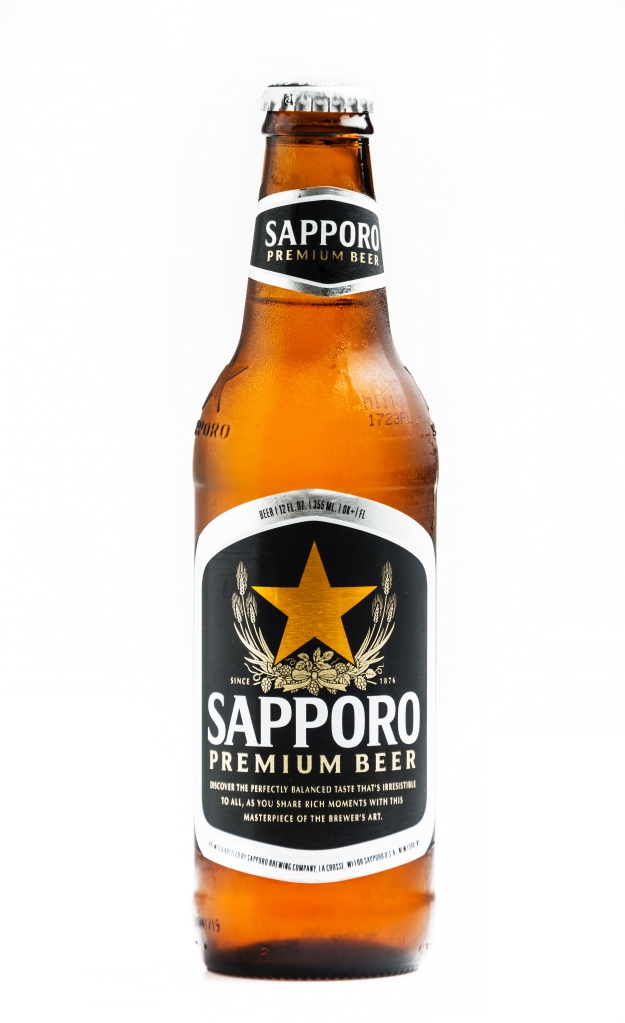 A bottle of Sapporo Premium Beer against a white background. 